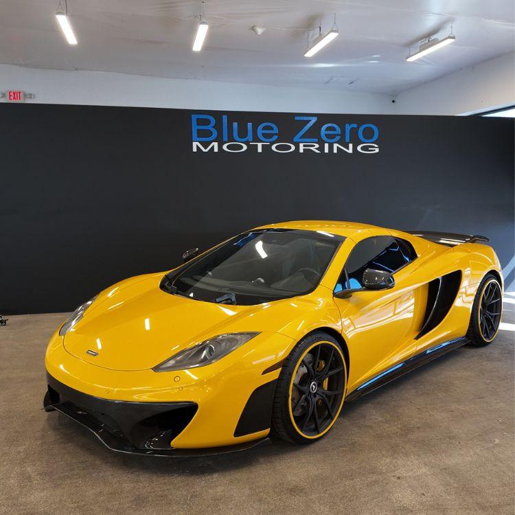 Yellow sports car parked inside the Blue Zero Detailing service bay